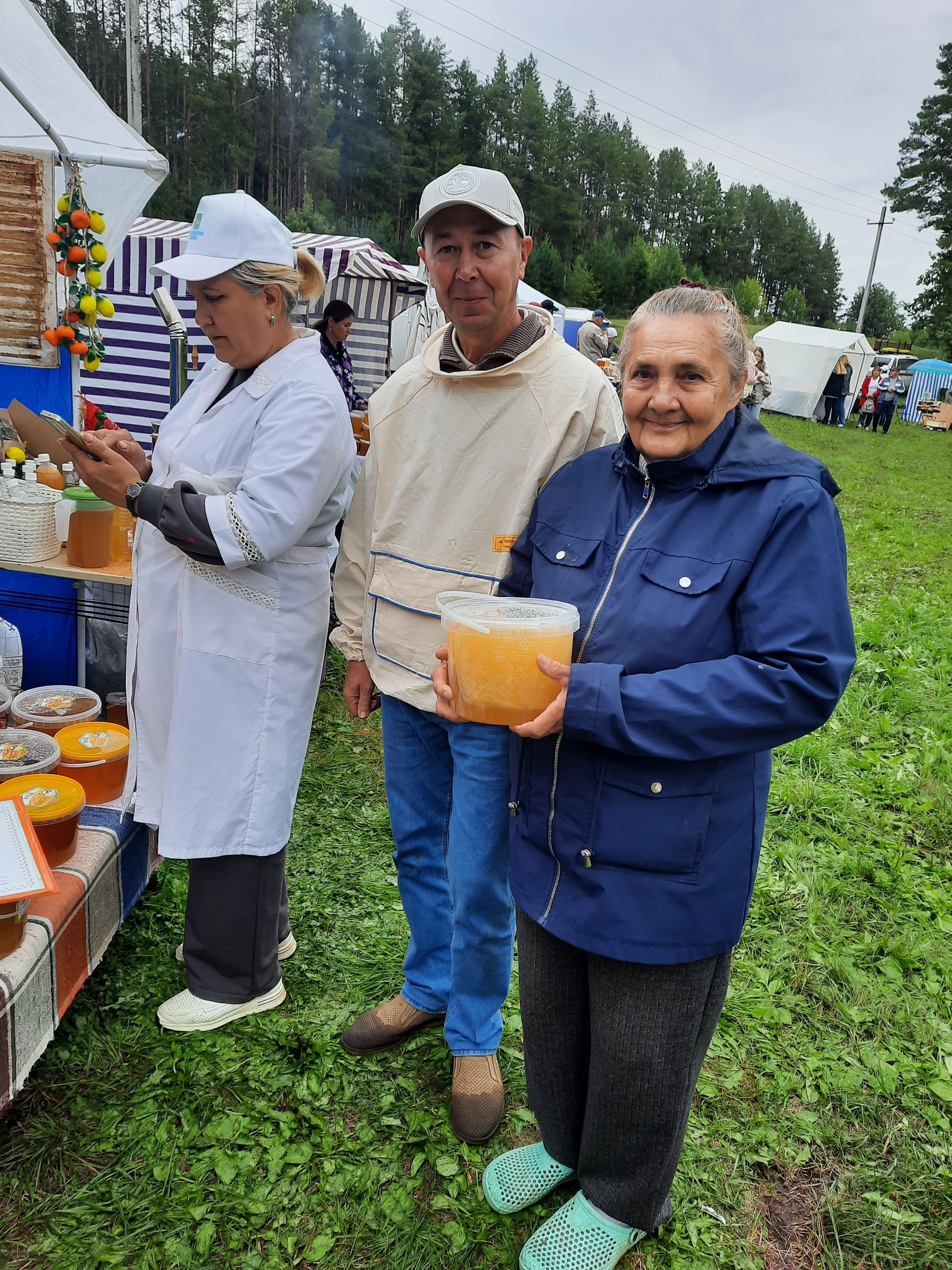 Глава Бимского сельского поселения, известный пчеловод Эдуард Михайлов, знает все тонкости ремесла – и охотно делится ими с гостями.Посетительница праздника Лилия Вильданова внимательно слушает его советы. Август 2025 г. Фото из архива редакции.